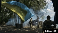 UKRAINE – Ukrainian soldiers fire a cannon near Bakhmut, an eastern city where fierce battles against Russian forces have been taking place, in the Donetsk region, May 12, 2023