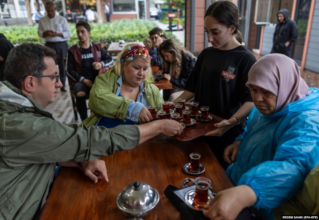 Ai turisti domestici viene servito il tè durante la loro visita a una piantagione di tè a Trabzon.  Con una crisi del costo della vita, la diminuzione delle riserve estere e la lira che ha raggiunto minimi storici, Ankara ha respinto decine di migliaia di afghani al suo confine terrestre con l'Iran o li ha deportati direttamente in Afghanistan.   