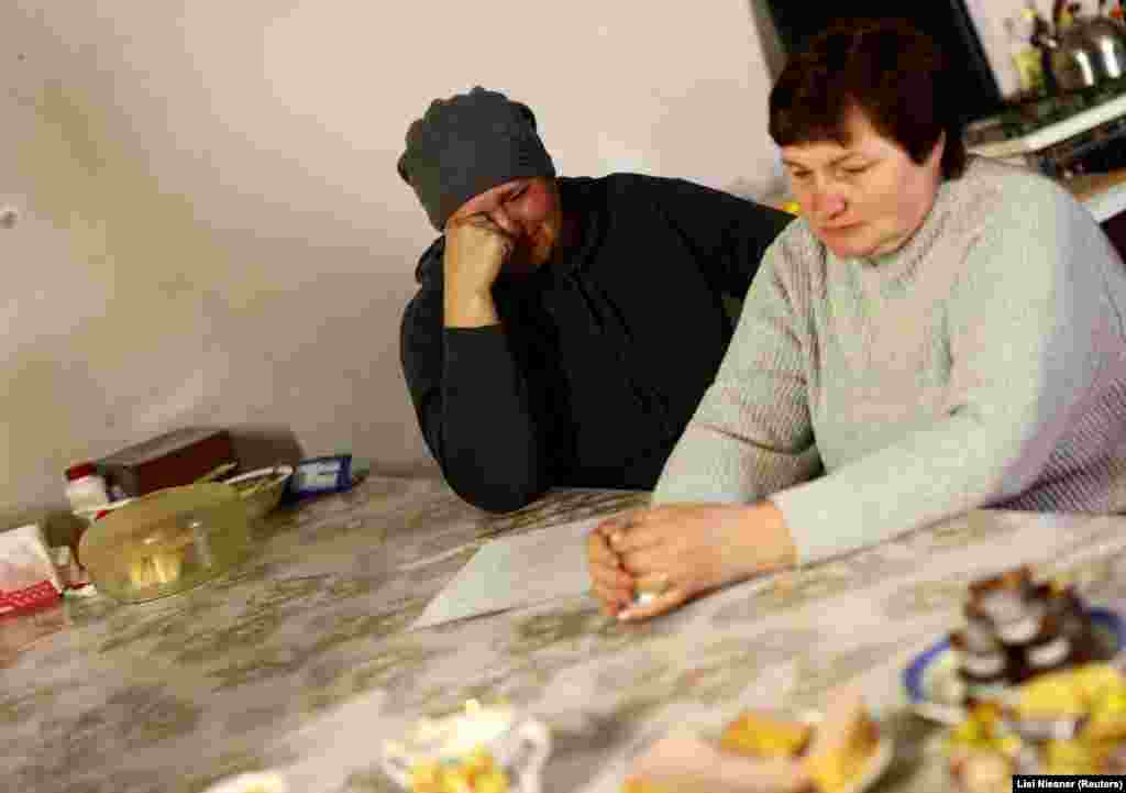 Szomszédjuk, Irina Szicskar (balra) Szvitlanával beszélgetve siratja fiát. A férfit a háború elején Mariupolban fogságba ejtették, és nem tudni, hogy életben van-e. &bdquo;Csak azért imádkozom, hogy hazajöjjön&rdquo; &ndash; mondja a nő
