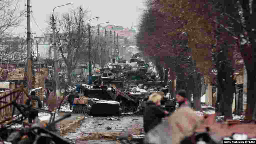 Civilians look at a destroyed Russian armored column in Bucha on March 1, 2022. Two days later, the town was occupied by Russian troops.