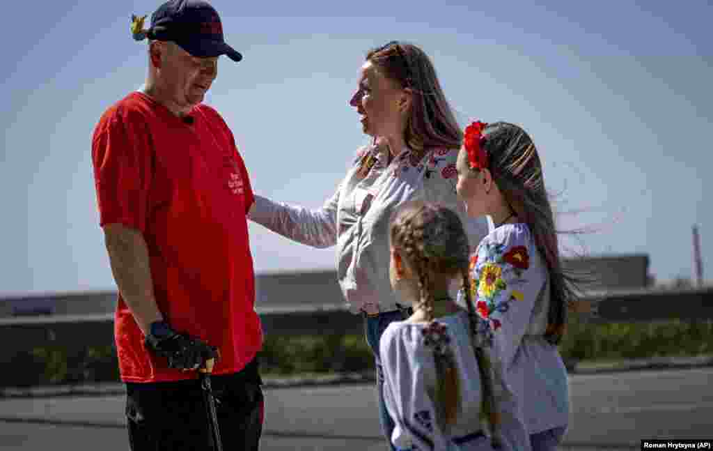 A woman and her daughters greet Khrapko during his walk along the highway. With their journey being followed on social media, the pair were an inspiration to many Ukrainians who started giving them donations.