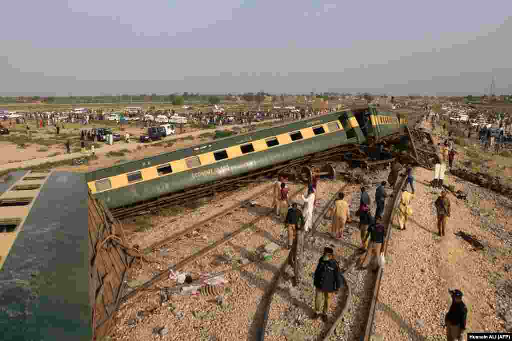 Oficialii de poliție inspectează vagoanele la locul accidentului după deraierea unui tren de pasageri în Nawabshah, Pakistan, pe 6 august. Cel puțin 31 de persoane au fost ucise.