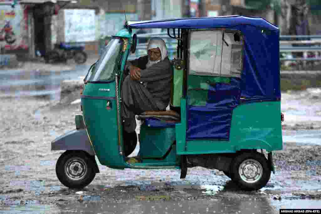 A man looks on from inside of his vehicle during heavy rain in Peshawar, Pakistan, on April 15, in a region where at least 29 people died in torrential rain and lightning strikes.