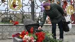Женщина приносит цветы к мемориалу, установленному в память о погибших в Краматорске во время российского обстрела железнодорожного вокзала 8 апреля 2022 года