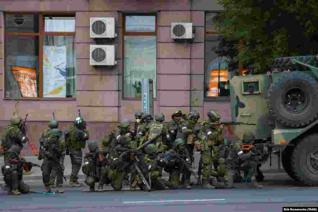 مردان مسلح پشت یک خودروی زرهی در بیرون مقر منطقه نظامی جنوب روسیه موضع گرفته&zwnj;اند