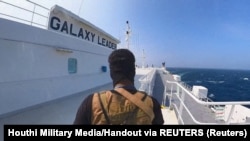 Një luftëtar i lëvizjes rebele Huthi, në anijen Galaxy Leader, që rebelët kanë kapur në Detin e Kuq. 20 nëntor 2023. 