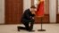 Moldovan Prime Minister Dorin Recean kneels in front of the national flag during a swearing-in ceremony in Chisinau on February 16.