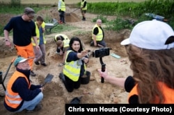 Учасники розкопок демонструють знахідку – мушкетну кулю