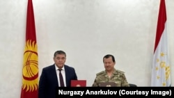 The chairman of Kyrgyzstan's Committee for National Security, Kamchybek Tashiev (left) and his Tajik counterpart, Saimumin Yatimov in the Kyrgyz border town of Batken on October 2. 