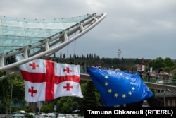 People hang an EU and Georgian flag from a bridge in Tbilisi on the country's independence day, May 26.