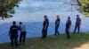 Serbian Police officers search a bank of the Drina River after a boat full of migrants capsized overnight on August 21-22. 