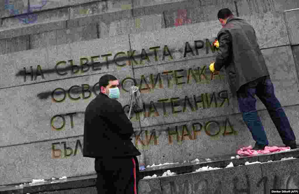 Members of the Bulgarian Socialist Party cleaning the monument after vandals defaced the controversial message of &ldquo;gratitude&rdquo; in February 2011.