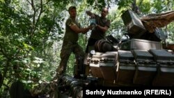 Українські військові завантажують снаряди в трофейний російський танк Т-80 поблизу Бахмута, 19 червня 2023 року