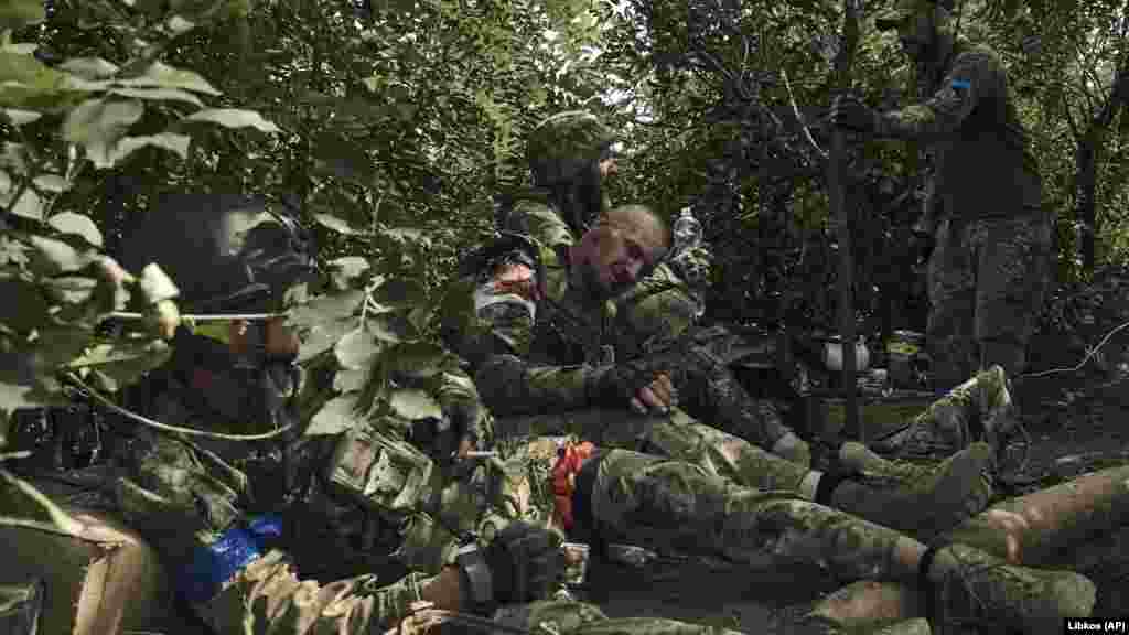 Wounded soldiers wait for a medical evacuation.