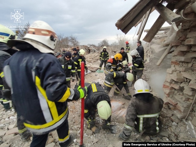 Рятувальники розгрібають завали двох повністю зруйнованих російською ракетою приватних будинків у Злочівському районі. Оточуючі будівлі теж зазнали ушкоджень. Львівщина, Україна. 9 березня 2023 року