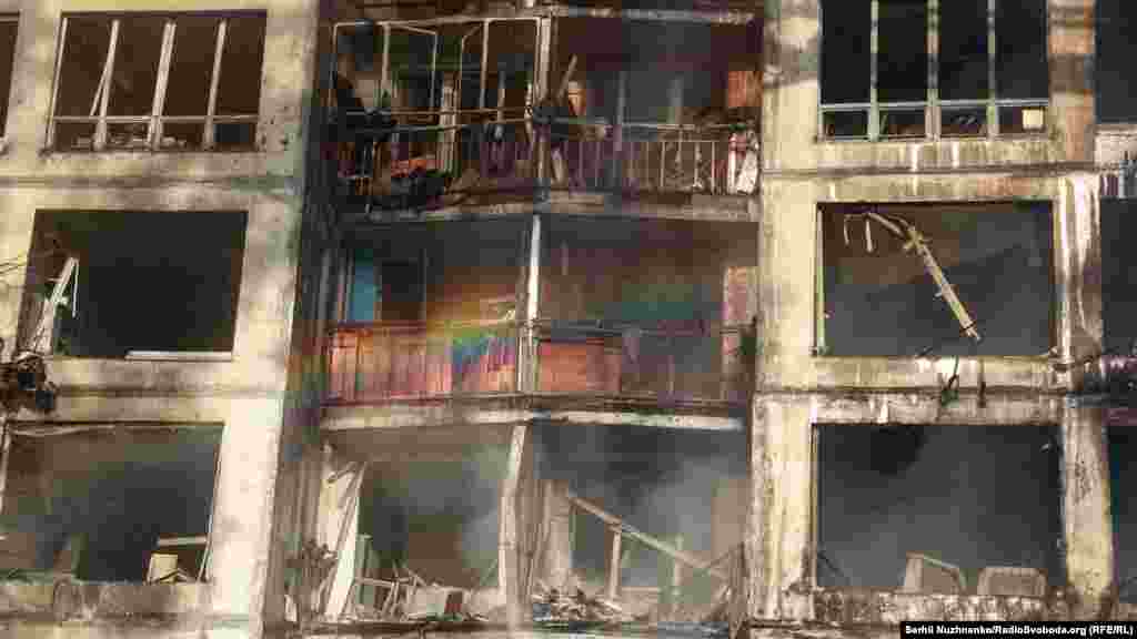 На тлі зруйнованого внаслідок російського обстрілу, як встановили правоохоронні органи, житлового будинку в Святошинському районі виникла Веселка під час гасіння пожежі, Київ, 15 березня 2022 року