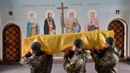 Ukrainian soldiers carry the coffin of a lieutenant colonel killed in battle during his funeral in Kyiv on February 27.