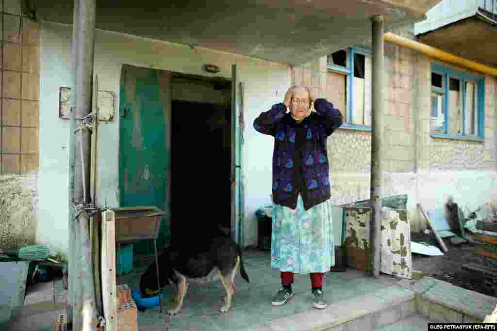 Natalya, 90, stands at the entrance to her apartment block.&nbsp; Life is especially difficult for older residents as they risk serious injury or death when venturing out.