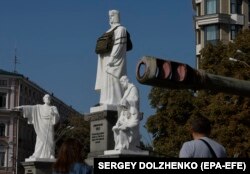 O vestă antiglon uriașă a fost pusă pe monumentul prințesei Olga lângă o expoziție de mașini militare rusești distruse în Piața Mykhailivska din Kiev, pe 13 septembrie 2023