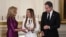 U.S. first lady Jill Biden (left) and Secretary of State Antony Blinken (right) present an International Women of Courage award to Benafsha Yaqoobi during an awards ceremony on March 4 at the White House in Washington.