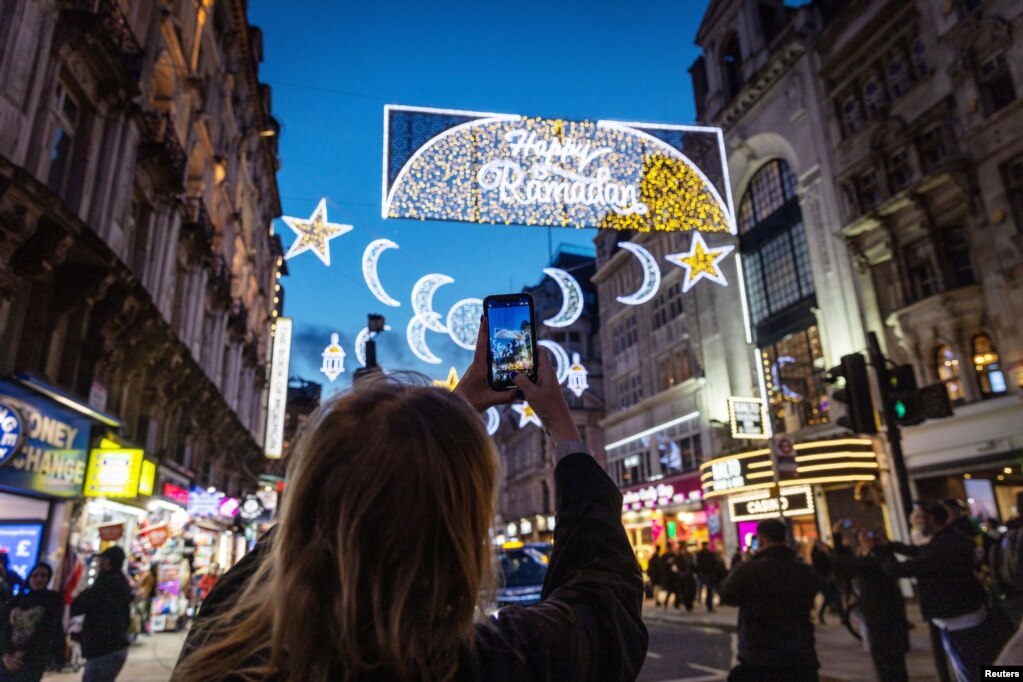 Një grua duke fotografuar zbukurimet me drita ku shkruan "Gëzuar Ramazanin", në Piccadilly Circus në nisje të muajit të Ramazanit, në Londër, Britani e Madhe, 21 mars 2023.
