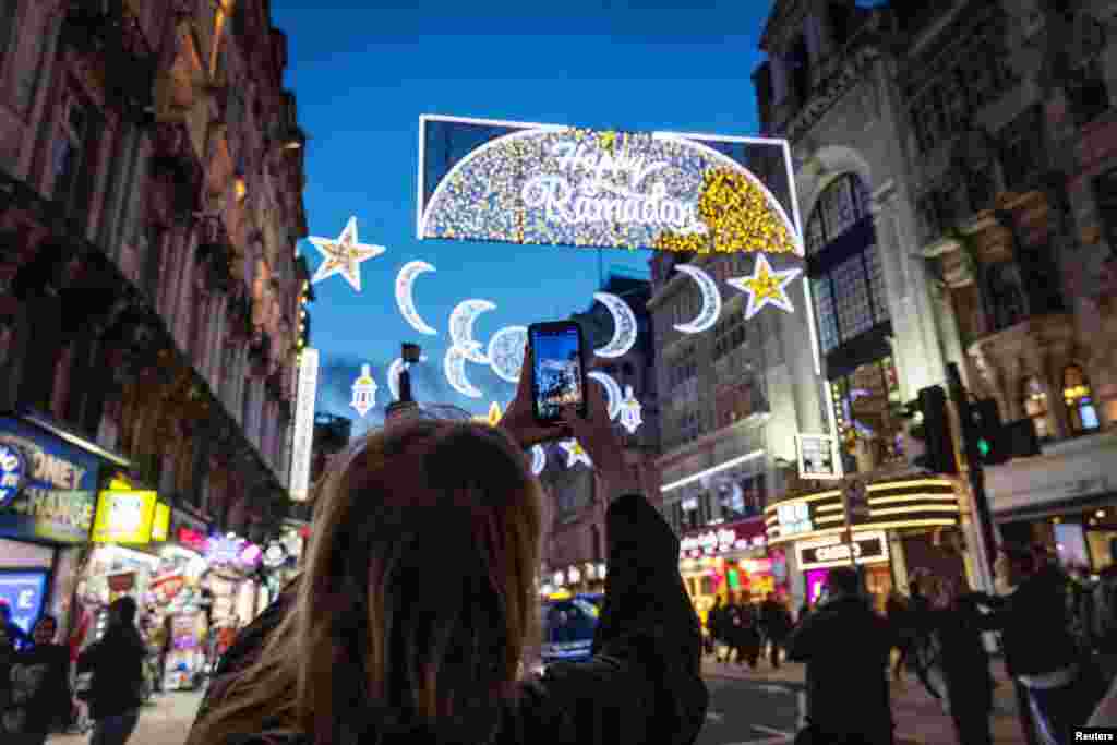 Një grua duke fotografuar zbukurimet me drita ku shkruan &quot;Gëzuar Ramazanin&quot;, në Piccadilly Circus në nisje të muajit të Ramazanit, në Londër, Britani e Madhe, 21 mars 2023.&nbsp;
