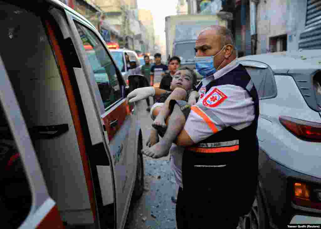 Një punonjës mjekësor bart një fëmijë të lënduar në një sulm izraelit në Khan Younis, në Rripin jugor të Gazës, 19 tetor 2023.