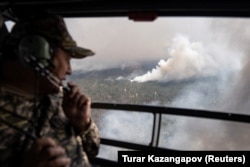 Команда МЧС на вертолёте облетает площадь лесного пожара в Абайской области. 12 июня 2023 года