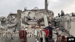 Disa palestinezë vëzhgojnë shkatërrimin në qytetin jugor të Gazës, Rafah.
