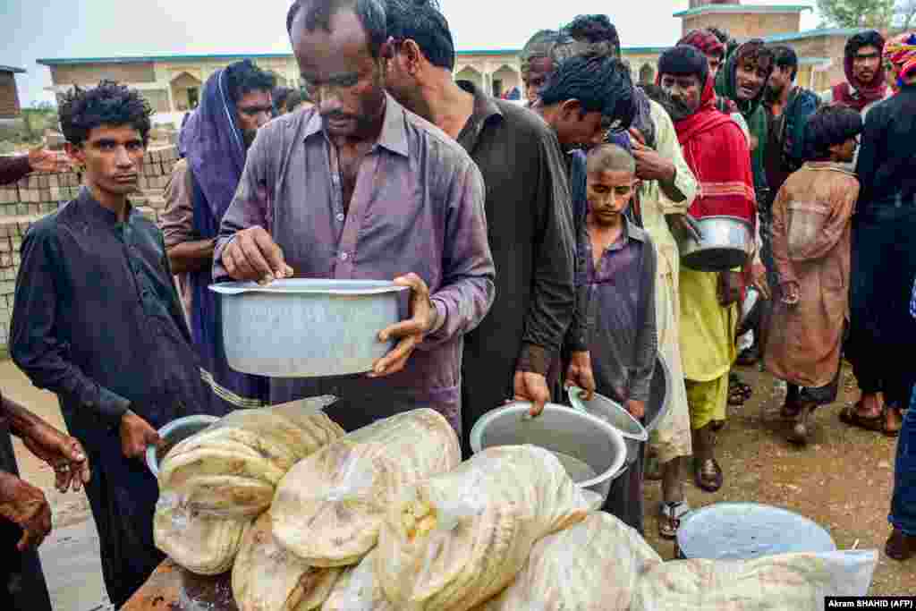 Cyclone evacuees receive food near a temporary shelter set at a school in a coastal area in Sujawal of Pakistan&#39;s Sindh Province.