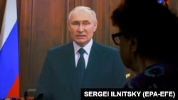 Женщина смотрит телеобращение президента России Владимира Путина. Москва, 24 июня 2023 года