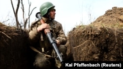 A Ukrainian soldier scouts for enemy positions from a trench in Ukraine's east. (file photo)