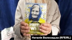 Українка Олександра Васейко тримає книжку «Оповідання з Волині», в якій йдеться про неї та її батька. Варшава, 2023 рік