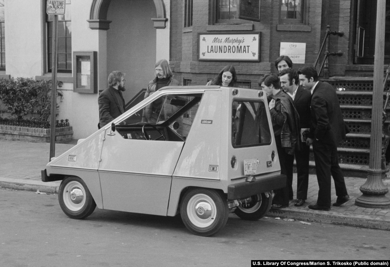 Njerëzit mblidhen rreth një CitiCar (veturë elektrike) në një qytet të paspecifikuar amerikan. Automjeti 600 kilogramësh nisi të prodhohej më 1974 pasi kriza me naftë arriti kulmin. Gjithsej 4.444 vetura të tilla u prodhuan para heqjes nga përdorimi më 1977.