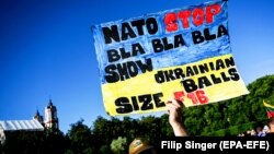 Чоловік тримає плакат, коли люди збираються на концерт #UkraineNato33 на підтримку України під час саміту НАТО. Вільнюс, Литва, 11 липня 2023 року