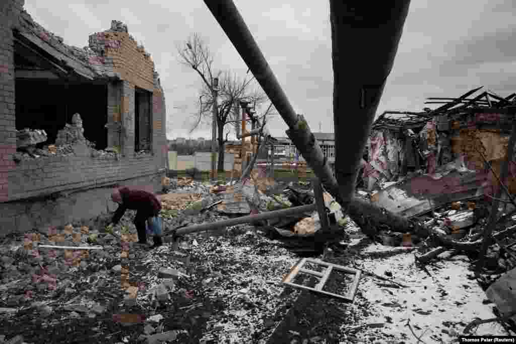 Nadezhda Prokopenko clears debris in the yard of the house of a relative that was destroyed in a Russian missile strike in Selydove, near Avdiyivka, Ukraine.