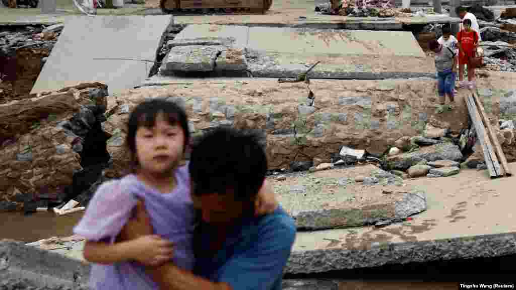 Helyiek kelnek át egy, a Doksuri tájfun által megrongálódott hídon a kínai Hebej tartománybeli Csucsuban 2023. augusztus 7-én.&nbsp;A Doksuri tájfun okozta esőzések és áradások hatalmas pusztítást okoztak Kínában. A halálos áldozatok számát még nem közölték a hatóságok, de feltehetően több tucat ember vesztette életét az elmúlt hetekben