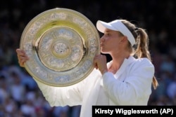Kazakhstan's Elena Rybakina kisses the trophy as she celebrates after beating Tunisia's Ons Jabeur to win the final of the ladies' singles in London on July 9, 2022.