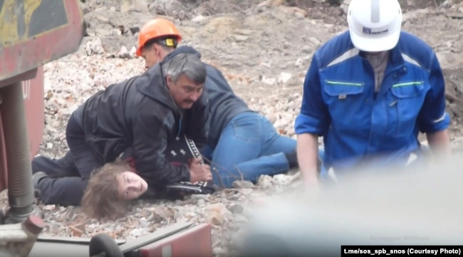 Workers forcibly detain protesting student Kirill Kaverin in St. Petersburg in May.