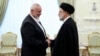 In this photo released by the Iranian president's office, President Ebrahim Raisi (right) greets the leader of the Palestinian militant group Hamas, Ismail Haniyeh, in Tehran on June 20.