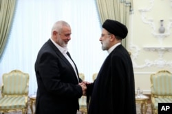 Iranian President Ebrahim Raisi (right) greets the leader of Hamas, Ismail Haniyeh, in Tehran on June 20, 2023.