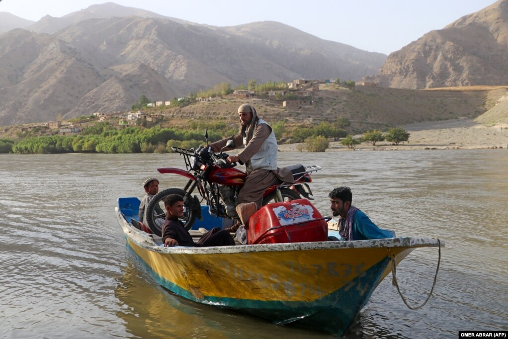 Burrat afganë duke bartur një motoçikletë në një varkë përtej lumit Kokça në rrethin Fayzabad të provincës Badakhshan.