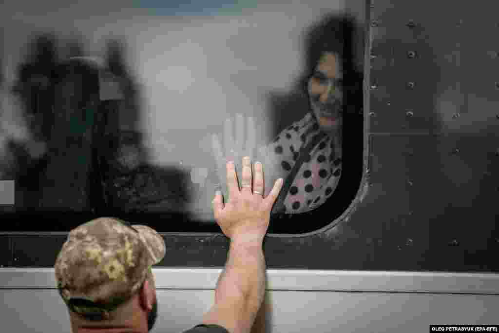 A couple bid farewell through the window of a train shortly before it departs from Kramatorsk.