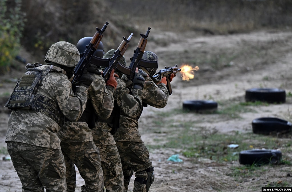 Un gruppo di 20 cittadini russi in uniforme ucraina si esercita a sparare con fucili d'assalto e mitragliatrici in un poligono di tiro fuori Kiev durante un'esercitazione militare per il neonato "Battaglione Siberiano".