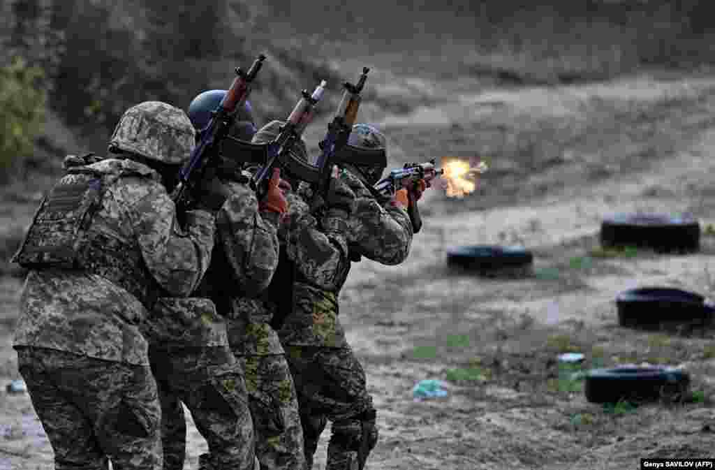 A group of 20 Russian citizens in Ukrainian uniforms practice firing assault rifles and machine guns at a shooting range outside Kyiv during a military exercise for the newly formed &quot;Siberian Battalion.&quot;