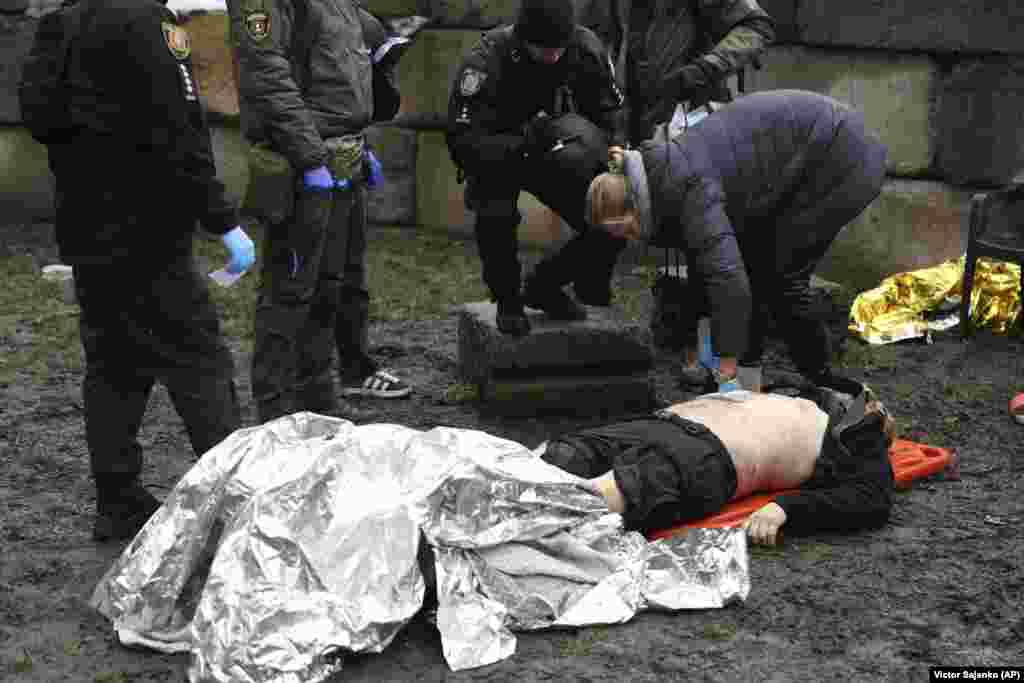 A victim is laid out as emergency responders attend to his wounds.