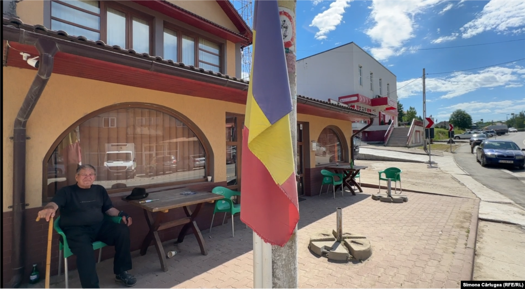 Un steag rupt atârnă pe un stâlp în centrul comunei.