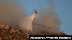 Një helikopter i përfshirë në shuarjen e zjarreve në lindje të Athinës më 13 gusht 2024. 