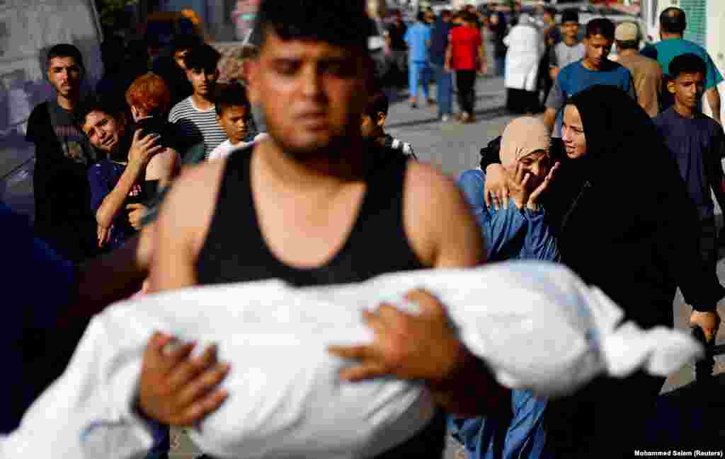 Egy férfi egy izraeli csapásban megölt palesztin gyermek holttestét viszi a Gázai övezet déli részén fekvő Hán Júnisz kórháza előtt 2023. október 17-én.&nbsp;Egy palesztin szervezet szerint tizenöt percenként hal meg egy gyermek a Gázai övezetet érő izraeli bombázásokban