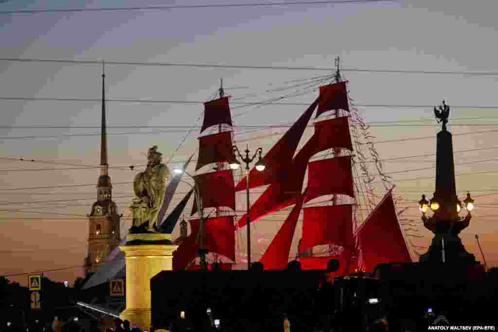 A frigate with red sails floats on the Neva River during a general rehearsal for the Scarlet Sails celebration in St. Petersburg, Russia.